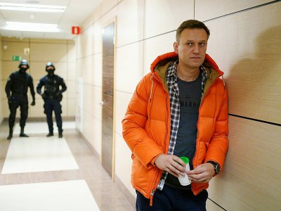 Le principal opposant au Kremlin, Alexeï Navalny surveillé par des agents des forces de sécurité, dans le hall d'un bâtiment qui abrite sa Fondation anti-corruption (FBK, le 26 décembre 2019 à Moscou - Dimitar DILKOFF [AFP/Archives]