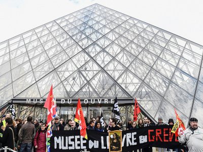 Des employés et des syndicalistes en grève devant la pyramide du Louvre à Paris le 17 janvier 2020 - ALAIN JOCARD [AFP]