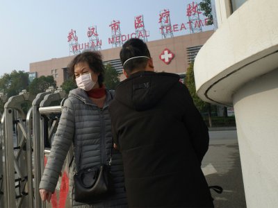 Une femme quitte le centre de traitement médical de Wuhan - Noel Celis [AFP]
