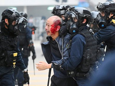 Des policiers arrêtent un homme blessé après avoir dispersé une manifestation sur la place de Chater Garden, à Hong Kong le 19 janvier 2020 - Philip FONG [AFP]