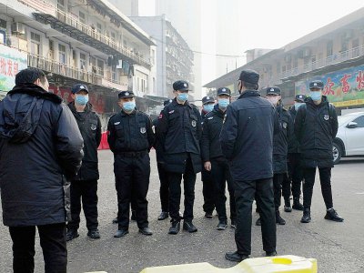 Des agents de sécurité devant un marché de fruits de mer fermé à Wuhan (Chine) pour cause de suspicion de virus, le 11 janvier 2020 - NOEL CELIS [AFP]