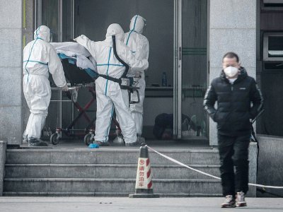 Du personnel médical transportent un malade à l'hôpital Jinyintan de Wuhan, où sont traités des patients infectés par un mystérieux virus, analogue au Sras, le 18 janvier 2020 - STR [AFP]