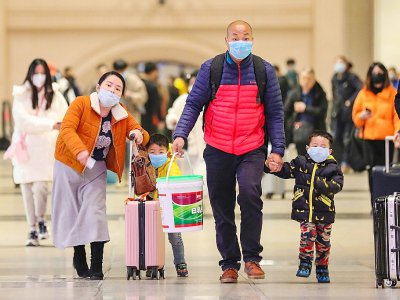Des voyageurs portant un masque sur la bouche à la gare de Hankou à Wuhan (Chine), le 21 janvier 2020 - - [AFP]