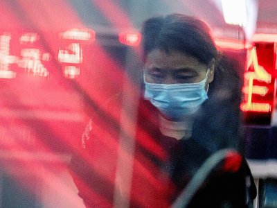 Une femme munie d'un masque respiratoire aux abords d'une gare de Pékin, le 22 janvier 2020 - NICOLAS ASFOURI [AFP]