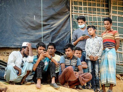 Des réfugiés Rohingyas regardent sur un téléphone portable le procès intenté à la Birmanie devant la Cour internationale de justice de La Haye, le 11 décembre 2019 dans un camp à Ukhia, au Bangladesh - MUNIR UZ ZAMAN [AFP/Archives]