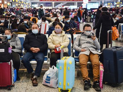 Des passagers équipés de masques de protection attendent leur train pour aller voir leur famille à l'occasion du Nouvel An chinois, à Shanghai le 23 janvier 2020 - HECTOR RETAMAL [AFP]
