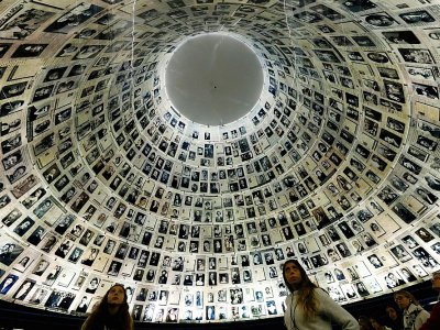 Des visiteurs regardent le mur recensant les noms et visages de victimes de la Shoah, au mémorial de Yad Vashem, le 20 janvier 2020 à Jérusalem - Emmanuel DUNAND [AFP/Archives]