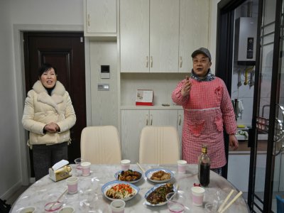 Pen Lixing prépare le 24 janvier 2020 le repas du réveillon du Nouvel an chinois avec son épouse Wang Yangong à Wuhan, ville coupée du reste du monde en raison de la propagation d'un nouveau coronavirus. - Hector RETAMAL [AFP]