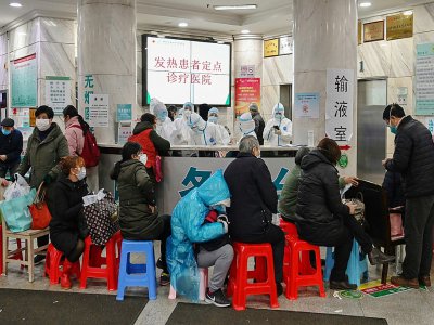 Du personnel médical en combinaison de protection reçoit des patients à l'hôpital de la Croix-Rouge à Wuhan, le 24 janvier 2020 en Chine - Hector RETAMAL [AFP]
