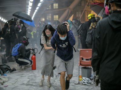 Des manifestants courent se mettre à l'abri des tirs de gaz lacrymogènes de la police, le 18 novembre 2019 à Hong Kong - Anthony WALLACE [AFP/Archives]