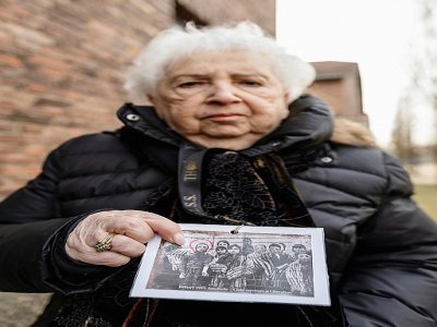 Une survivante de l'Holocauste, Miriam Ziegler, montre une photo d'elle et d'autres prisonniers du camp nazi d'Auschwitz-Birkenau - Wojtek RADWANSKI [AFP]