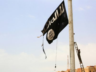 Un drapeau du groupe jihadiste Etat islamique (EI) décroché par un combattant kurde, le 30 avril 2017 dans la région de Raqa, en Syrie - DELIL SOULEIMAN [AFP/Archives]