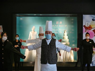 Des employés d'hôtel lors d'un briefing de sécurité à Wuhan  mardi 28 janvier 2020 - Hector RETAMAL [AFP]