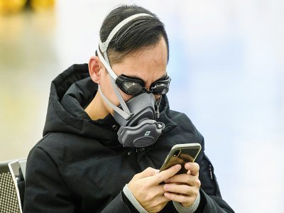 Un passager avec des lunettes de natation et un masque à la gare de Hong Kong qui relie ce territoire à la Chine continentale, le 28 janvier 2020 - Anthony WALLACE [AFP]