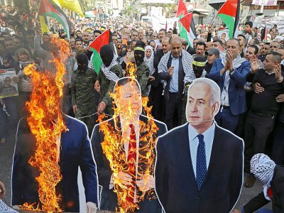Des représentations en carton de Donald Trump, du secrétaire d'Etat américain Mike Pompeo et de Benjamin Netanyahu brûlées par des manifestants palestiniens dans les rues de Naplouse en Cisjordanie, le 26 novembre 2019 - Jaafar ASHTIYEH [AFP/Archives]