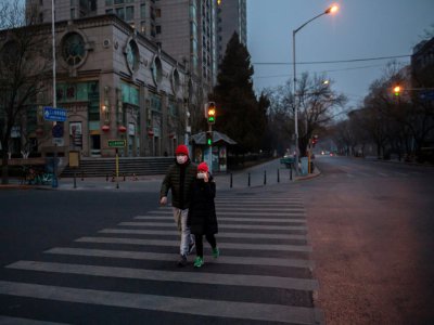 Des passants à Pékin le 28 janvier 2020 protégés par un masque - NICOLAS ASFOURI [AFP]
