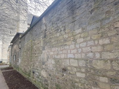 Un des tags avait été inscrit à la peinture rouge à cet endroit, sur le mur de l'aumônerie des étudiants à Caen.