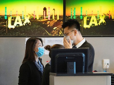 Membres d'une compagnie aérienne protégés par un masque à l'aéroport international de Los Angeles, le 29 janvier 2020 - Mark RALSTON [AFP]