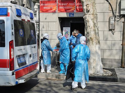 Une équipe médicale transporte un patient  soupçonné d'avoir contracté le coronavirus à Wuhan, le 30 janvier 2020 - Hector RETAMAL [AFP]