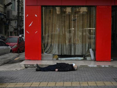 Un homme mort dans la rue à Wuhan, le 30 janvier 2020 en Chine - Hector RETAMAL [AFP]
