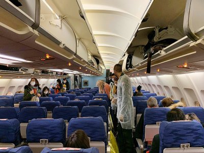 Des Français s'installent dans la nuit du 30 au 31 janvier 2020 à bord d'un avion en partance pour la France depuis Wuhan (Chine), foyer de l'épidémie de coronavirus - Hector RETAMAL [AFP]