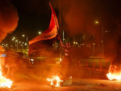 Un manifestant brandit le drapeau irakien à Najaf, au sud de Bagdad, le 1er février 2020 - Haidar HAMDANI [AFP]