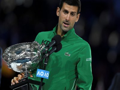 Le Serbe Novak Djokovic s'exprime avec le trophée après avoir remporté son 8e Open d'Australie, le 2 février 2020 à Melbourne - Greg Wood [AFP]