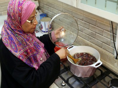 Moudi al- Miftah, Koweïtienne de 64 ans, cuisine des criquets dans sa maison à Al-Ahmadi, à 35 km au sud de la ville de Koweït, le 25 janvier 2020 - YASSER AL-ZAYYAT [AFP]