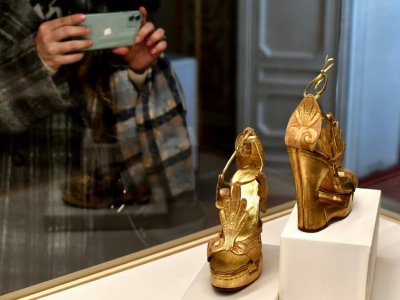 Une visiteuse de l'exposition "Aux pieds des dieux" photographie une paire de chaussures au Palais Pitti de Florence, le 30 janvier 2020 en Italie - Tiziana FABI [AFP]