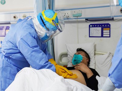 Un membre du personnel médical ausculte un patient porteur du nouveau coronavirus placé en isolement dans un hôpital de Zouping, dans la province chinoise de Shandong, le 28 janvier 2020 - STR [AFP]