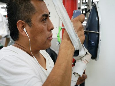 Un travailleur spécialisé manie un fer à repasser pour la confection d'un vêtement dans l'atelier Ferrara Manufacturing, le 16 janvier 2020 - TIMOTHY A. CLARY [AFP]
