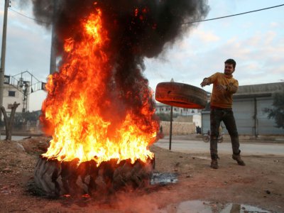 Un Syrien brûle des pneus pour brouiller la visibilité de l'aviation pro-régime, à Binnish, dans le nord-ouest de la Syrie, le 6 février 2020 - Omar HAJ KADOUR [AFP]