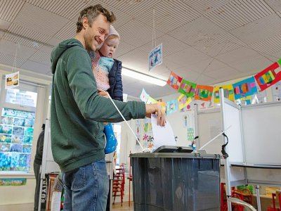 Un électeur accompagné de son enfant vote à Cork dans le sud de l'Irlande le 8 février 2020 - Paul Faith [AFP]
