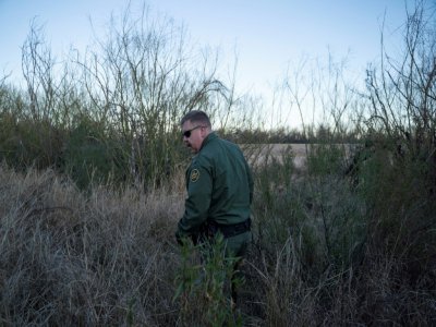 Le chef du poste de Presidio, Derek Boyle, marche dans les hautes herbes le long de la frontière séparant le Mexique des Etats-Unis le 29 janvier 2020 près de Presidio au Texas - Paul Ratje [Agence France-Presse/AFP]