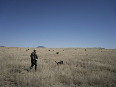 Le garde-frontière Jose Solis piste la trace de clandestins avec le chien renifleur Max, un berger malinois - Paul Ratje [AFP]