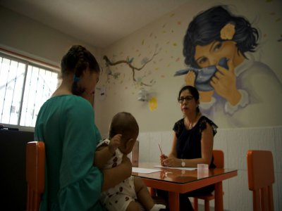Une jeune mère et son enfant devant la psychopédagogue Leonela Valerezo (d) dans le foyer "Valle Feliz" à Santo Domingo de los Colorados (Equateur), le 17 janvier 2020 - Rodrigo BUENDIA [AFP/Archives]