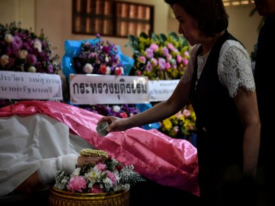 Une personne se recueille le 10 février 2020 à Nakhon Ratchasima devant le corps d'une des victimes de la tuerie sans précédent survenue dans cette ville du nord-est de la Thaïlande - Lillian SUWANRUMPHA [AFP]