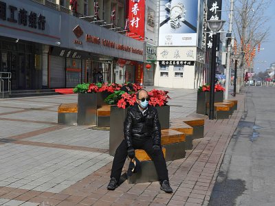 Un homme dans une rue déserte du quartier commercial de Wangfujingf, habituellement grouillant d'activité, le 10 février 2020 à Pékin - GREG BAKER [AFP]