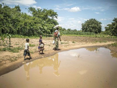 Loveness Haneumba et deux de ses enfants rentrent chez eux après avoir reçu une aide alimentaire, le 22 janvier 2020 à Simumbwe, en Zambie - Guillem Sartorio [AFP]