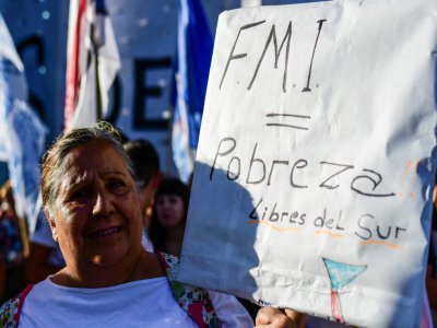 Une manifestante brandit le message "FMI = pauvreté" devant le Parlement argentin à Buenos Aires, le 12 février 2020 - RONALDO SCHEMIDT [AFP]