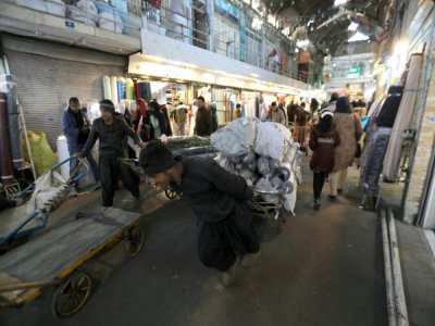 Un homme tire un chariot de marchandises dans le grand bazar historique de Téhéran, le 12 février 2020 - ATTA KENARE [AFP]