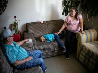 La petite Cristel, allongée entre ses parents - Pedro PARDO [AFP]