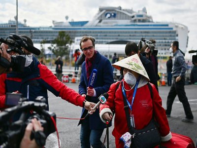 Une passagère débarquée du Diamond Princess est interrogée par des journalistes, le 19 février 2020 dans le port de Yokohama, au Japon - CHARLY TRIBALLEAU [AFP]