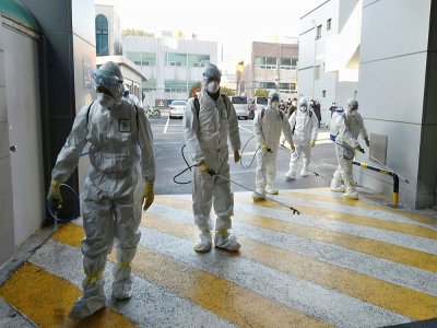 Des agents sanitaires désinfectent les abords d'une église où des cas de coronavirus ont été détectés, le 19 février 2020 à Namgu, en Corée du Sud - Handout [Daegu Metropolitan City Namgu/AFP]