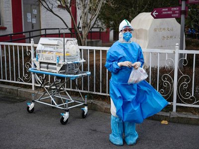 Un personne membre du personnel médical devant un incubateur entre des bâtiments d'un hôpital de Pékin, le 21 février 2020 - GREG BAKER [AFP]