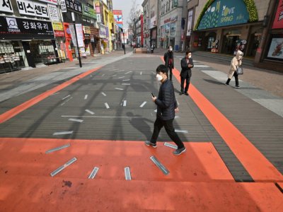 Des piétons portent des masques de protection dans une rue de Daegu, le 21 février 2020 en Corée du Sud - Jung Yeon-je [AFP]