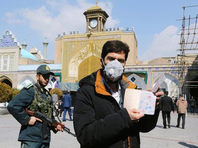 Un Iranien porte un masque de protection pour aller voter aux élections législatives, dans la banlieue de Téhéran, le 21 février 2020 - ATTA KENARE [AFP]