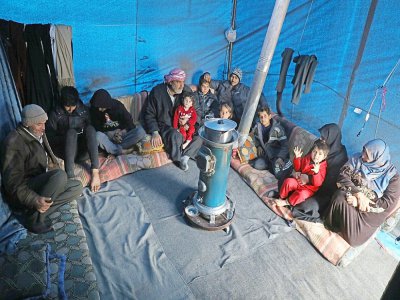 Une famille syrienne installée dans un camp de déplacés informel, près du village de Kafr Lusin, à la frontière turque, dans le nord d'Idleb, le 21 février 2020 - AAREF WATAD [AFP]