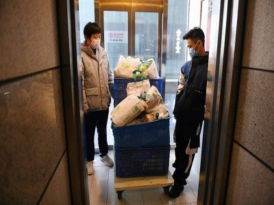 Des employés d'un restaurant livrent des provisions à domicile, le 18 février 2020 à Tongzhou, dans l'est de Pékin - GREG BAKER [AFP]