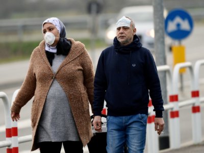Des habitants équipés de masques de protection photographiés le 23 février 2020 à l'entrée de la petite ville de Casalpusterlengo, près de Milan en Italie, pays le plus touché en Europe par le coronavirus - Miguel MEDINA [AFP]